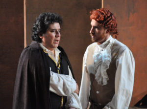 Des Grieux (Percy Martinez, left) learns that Lescaut (Nathan Matticks, right) has bribed a guard to free Manon from prison.
